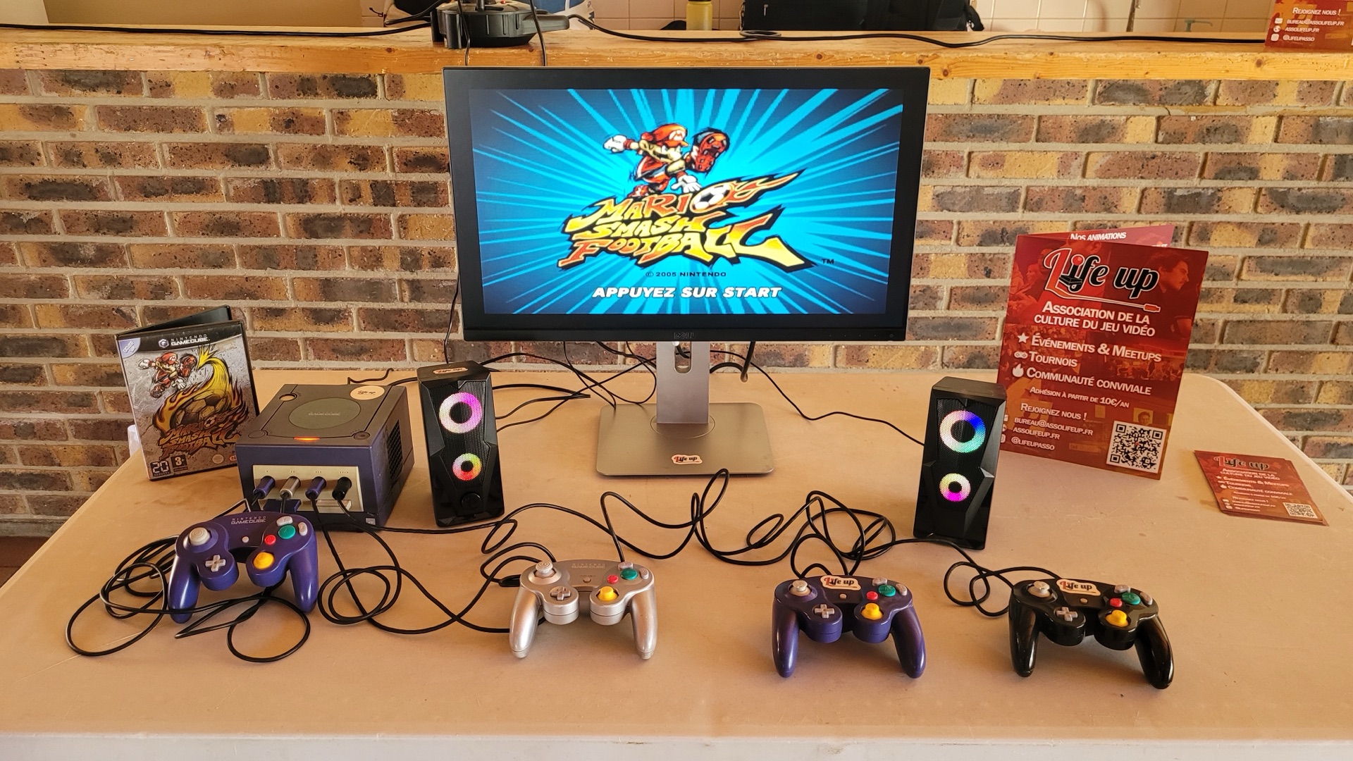 Un poste rétro avec une GameCube et quatre manettes, prêt à jouer ensemble